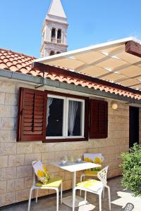 a patio with a table and chairs and a building at Supetar Apartment City Center in Supetar