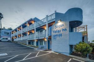 una vista exterior de un hotel con aparcamiento en Silicon Valley Inn, en Belmont
