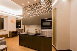 eine Küche mit einem Herd und einer Mikrowelle in der Unterkunft Civico Cinque Home Luxury Apartment in Salerno