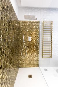 ein Bad mit einer Dusche und einer goldenen Wand in der Unterkunft Civico Cinque Home Luxury Apartment in Salerno