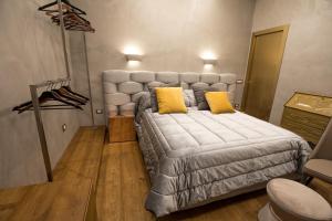 a bedroom with a large bed with yellow pillows at Civico Cinque Home Luxury Apartment in Salerno
