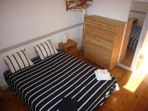 1 dormitorio con cama de rayas en blanco y negro y vestidor en Encantadora Casa do Limoeiro en Lisboa