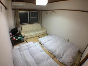a small room with a bed and a couch at Kenroku Haitsu 203 in Kanazawa