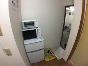a kitchen with a microwave on top of a stove at Kenroku Haitsu 203 in Kanazawa