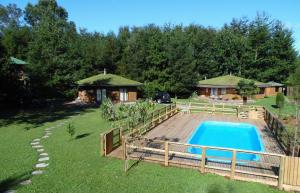 a backyard with a pool and a house at Complejo Cabañas Quilamalen in Villarrica