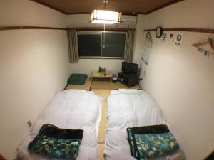 a small room with two beds and a desk at Kenroku Haitsu 205 in Kanazawa
