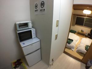 a room with a microwave on top of a counter at Kenroku Haitsu 205 in Kanazawa +10 photos