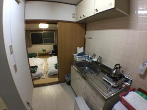 a small kitchen with a sink and a room at Kenroku Haitsu 205 in Kanazawa