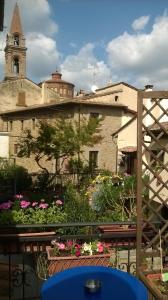 een gebouw met een klokkentoren en wat bloemen bij Casa Traquandi in Castiglion Fiorentino