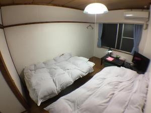 Un dormitorio con dos camas y una mesa y una lámpara. en Kenroku Haitsu 305, en Kanazawa