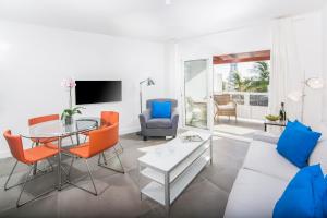 a living room with a glass table and orange chairs at Rooms & Suites The Lighthouse in Tías