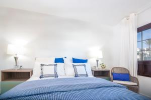 a bedroom with a blue and white bed and a window at Rooms & Suites The Lighthouse in Tías