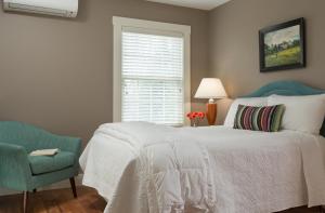 a bedroom with a bed and a chair and a window at Sugar Hill Inn in Sugar Hill