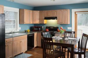 a kitchen with wooden cabinets and a table with chairs at Sugar Hill Inn in Sugar Hill
