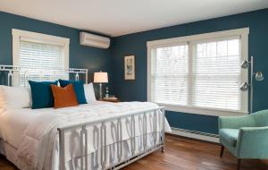 a bedroom with blue walls and a bed and a chair at Sugar Hill Inn in Sugar Hill