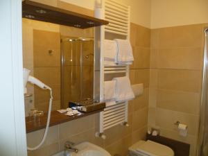 La salle de bains est pourvue d'une douche, de toilettes et d'un lavabo. dans l'établissement Albergo Sole, à Mariano Comense