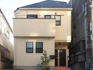 une maison blanche avec un toit noir dans l'établissement COTO Tokyo Shibuya 3, à Tokyo