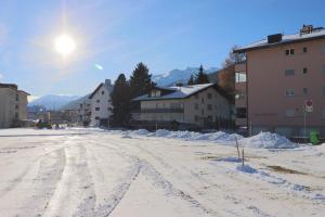 eine schneebedeckte Straße in einer Stadt mit Gebäuden in der Unterkunft Casa Pramalinis - Manstein in Davos