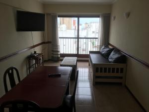 sala de estar con sofá y ventana en Departamento 2 ambientes Mar del Plata en Mar del Plata