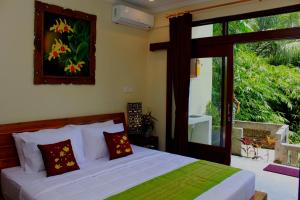 una camera con un letto e una grande finestra di Manwarsa Guest House ad Ubud