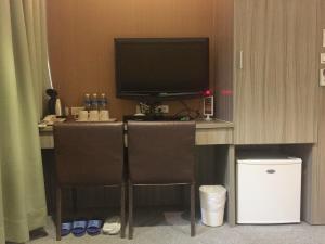 a desk with a television and two chairs in a hotel room at Royal Hotel in Taipei +25 photos