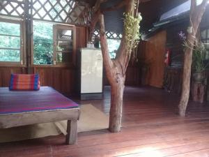 a room with a tree and a refrigerator in it at Koh Kood Little Hut in Ko Kood