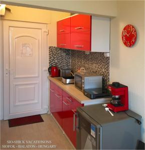 シオーフォクにあるSioShick Vacationsの赤いキャビネットと赤い電子レンジ付きのキッチンが備わります。