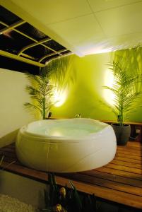 a bath tub in a bathroom with two plants at Hotel KBC (Love Hotel) in Saga