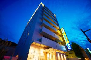 a tall building with a sign in front of it at Super Hotel Ogaki Ekimae in Ogaki