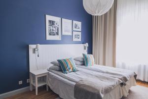 a bedroom with blue walls and a bed with pillows at Smögens Hafvsbad in Smögen