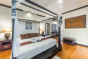 um quarto com uma cama grande e uma mesa em Gassan Khuntan Golf & Resort em Mae Tha