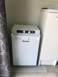 a small white stove in a kitchen next to a refrigerator at 40 Winks in Otorohanga