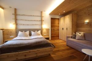 a bedroom with a large bed and a couch at Appartement Hotel Erlhof Deluxe in Lutago