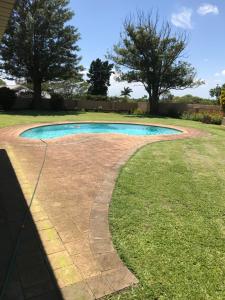 a stone walkway around a swimming pool in a yard at Ian and Pam's Flatlet in Empangeni