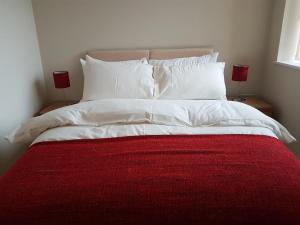 ウェストドライトンにあるStockley Apartments - Centralの白いベッド(赤毛布、ランプ2つ付)