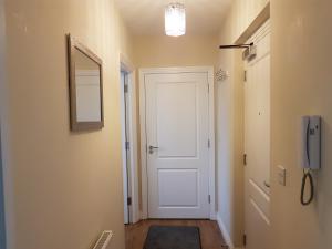 a hallway with a white door and a mirror at Stockley Apartments - Central in West Drayton +3 photos