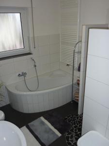La salle de bains est pourvue d'une baignoire et d'un lavabo. dans l'établissement Ferienwohnung Landwehr, à Großostheim
