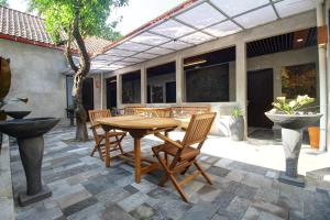 een houten tafel en stoelen op een patio bij Watu Agung Guest House in Borobudur