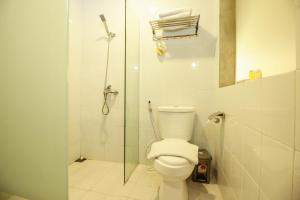 a bathroom with a toilet and a glass shower at Watu Agung Guest House in Borobudur