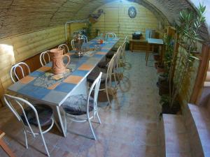 einen langen Tisch und Stühle in einem Zimmer mit Pflanzen in der Unterkunft Szlavi Apartman in Baja