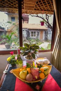una mesa con una bandeja de fruta y una ventana en Tam Coc Palm House, en Ninh Binh