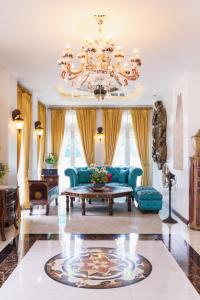 a living room with a blue couch and a chandelier at The Velvet Orchid in Chiang Mai