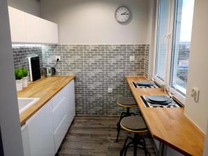 グディニャにあるGrey Apartament Centrum Gdyniaのキッチン(カウンター、スツール2つ付)