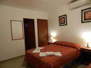 Una habitación de hotel con una cama con toallas. en Hotel Buenos Aires en Salta