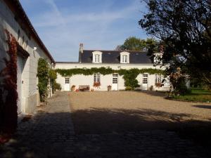 a large white house with a large driveway at La Jarillais in Saumur
