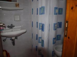 a bathroom with a sink and a shower curtain at Batika Rooms in Artemonas