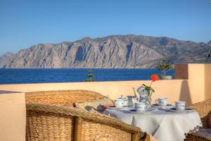 - une table sur un balcon avec vue sur l'océan dans l'établissement Hotel Mochlos, à Mochlos
