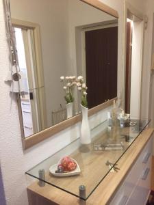 einen Tisch mit einem Spiegel und einem Blumenteller darauf in der Unterkunft Komfortables Appartement/Garconniere in Graz für Urlaub und Geschäftsreisen in Graz