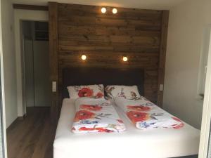 two beds in a bedroom with a wooden wall at Chasa Chalur in Fliess
