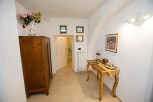 un corridoio con tavolo in legno e una camera di Antica Dimora B&B Canosa a Canosa di Puglia